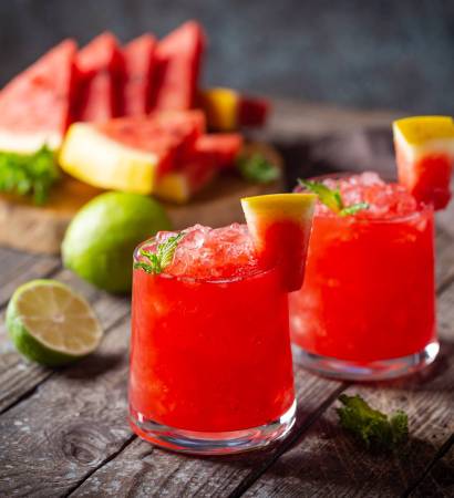 Refreshing cold summer watermelon drink in glasses with slices of watermelon and lime